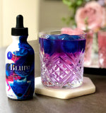 Deep blue ice cubes melting and showing color change with citrus in a cocktail